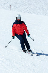 Fototapeta na wymiar Female skier in downhill slope. Winter sport recreational activity