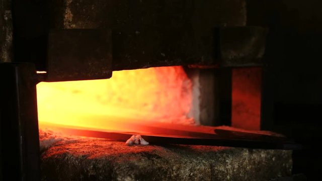 Making the sword out of metal at the forge. Heating of metal billets in the furnace.