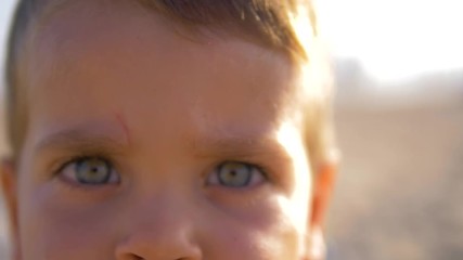4K Slow motion - Caucasian Child with blue eyes looking at the camera in a sunny day