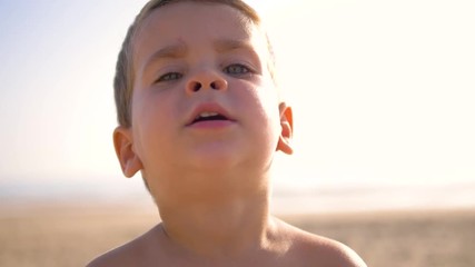 4K Slow motion - Caucasian Child with blue eyes looking at the camera in a sunny day