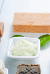 cosmetic clay, soaps, henna blocks, sponge and moisturizer on white wood table