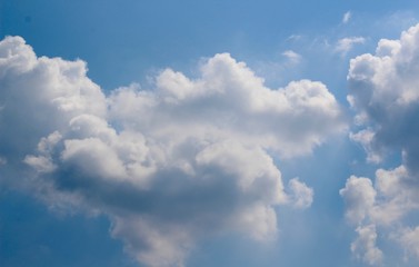 The white clouds in the blue sky on a sunny day.