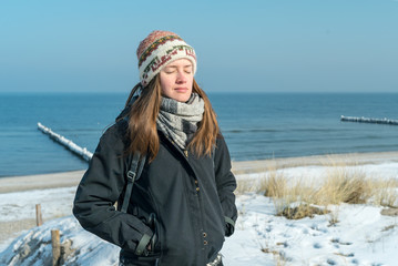 glückliche Frau am Meer im Winter mit geschlossenen Augen