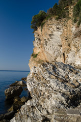 Large rocks are washed by clean, clear water of the Adriatic sea.