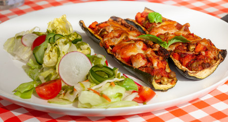 Healthy dinner plate - Zucchini stuffed vegetables and salad - letuce with cherry tomatoes, radish and cucumber
