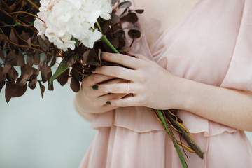 Bouquet tenu dans les mains et bague de fiançailles