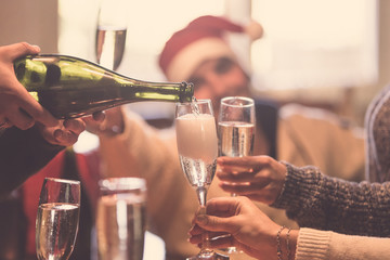 Christmas celebration with champagne - group of friends drinking and toasting together
