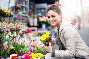 Young woman buying flowers on the streetmarket