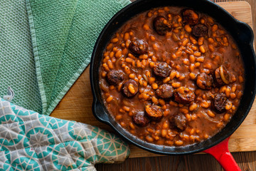 beans with sausage on a cast iron skillet