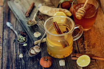 Vitamin medicinal tea with lemon and honey, ginger and spices on wooden background . The concept of spring beriberi and colds.
