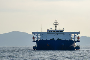 Blue and white colour project cargo ship anchors in the open sea. Project cargo ship is one of the type of Heavy-lift vessel use to carry very big size and heavy loads such as container ship.