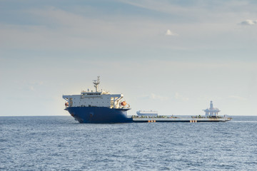 Obraz premium Blue and white colour project cargo ship anchors in the open sea. Project cargo ship is one of the type of Heavy-lift vessel use to carry very big size and heavy loads such as container ship.