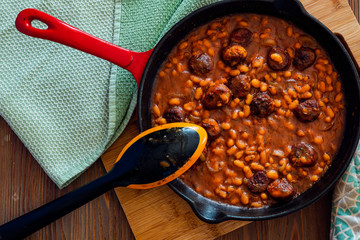 beans with sausage on a cast iron skillet