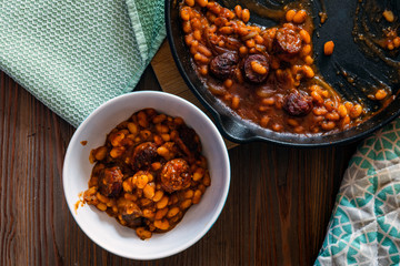 beans with sausage on a cast iron skillet