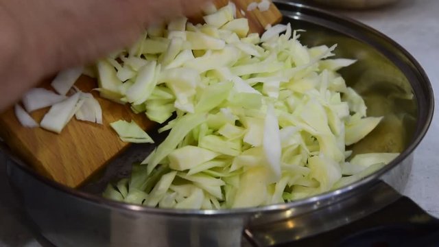 выкладка шинкованной капусты на сковороду для готовки