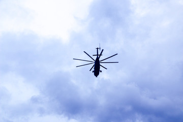 a large military helicopter hovers in the sky. A camouflaged helicopter flies at high speed.