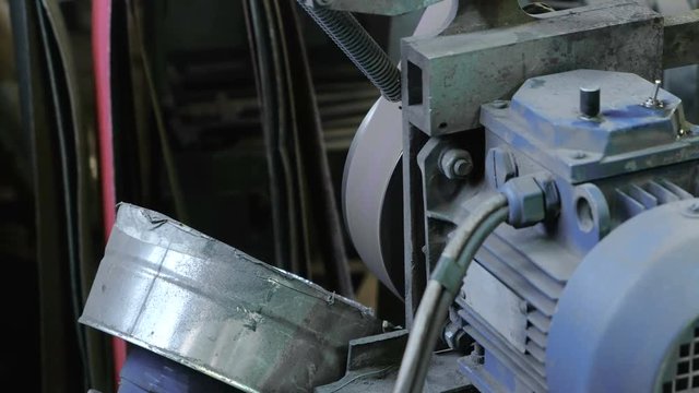 Working on a belt-grinding machine. Closeup.