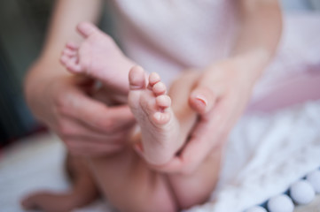 Obraz na płótnie Canvas Newborn baby hands and legs mother hands