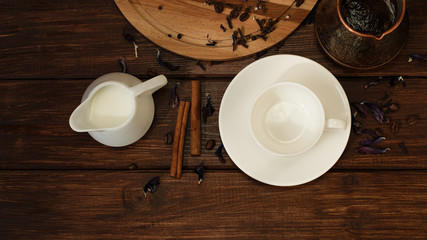 cup, milk and turk fresh coffee with cinnamon on a dark wooden table background