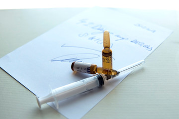 Doctor prescription  with two flacons and a syringe, close up