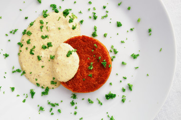 fried patty made of carrot, onion, and spices under sour cream mustard sauce decorated with parsley 