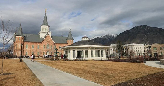 Provo Utah Mormon Temple spring day weddings. Springtime weather. Sacred church, historic building used for religion learning and training. People attending weddings and family.