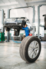 Wheel on the floor in tire service, car on lift