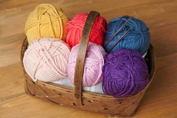 colorful wool yarn for knitting on wooden background