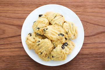 Butter cookies on white plate over wooden table. Top view.