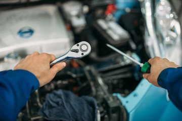 Male technician hands with screwdriver and wrench