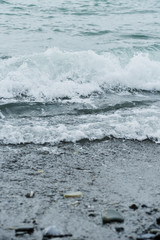 Fototapeta premium Sea wave surf crashing onto the pebble beach.