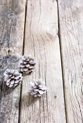 three white painted pine cones Christmas decoration on old rustic wooden table background