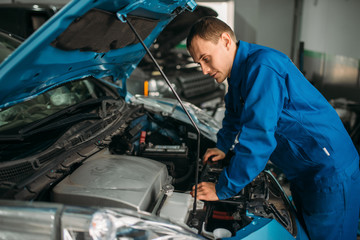 Mechanic repairs car engine, motor diagnostic