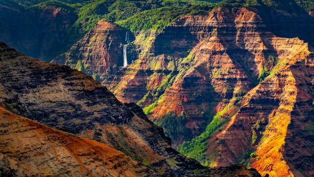Landscape detail of beautiful Waimea canyon colorful cliffs and waterfall, Kauai, Hawaii