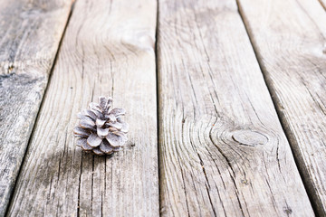 white painted pine cone Christmas decoration on old rustic wooden table background