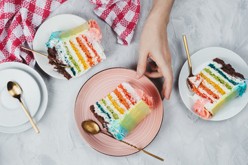 Flat lay of rainbow vegan cake pieces on grey background
