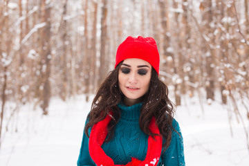 Happy young woman walking in winter time. Close up portrait of pretty girl in snowy nature