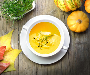 Pumpkin cream in autumn on a wooden table