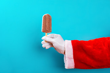 santa claus holding a red bean popsicle in front of a blue background