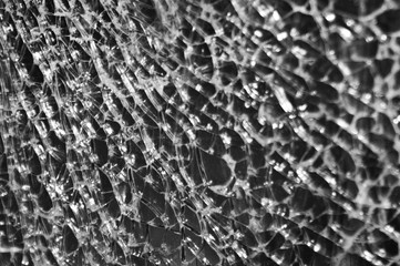 Black-and-white Texture of broken glass on dark background. Closeup