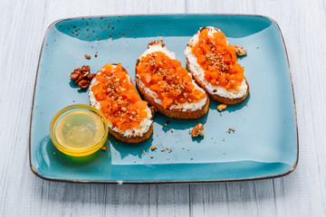 Tasty savory Italian appetizers, or bruschetta, on slices of toasted baguette garnished with basil