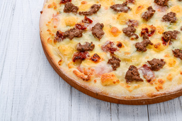 Minced meat tomato red onion pizza on a wood background. toning