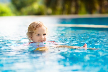 Fototapeta na wymiar Child in swimming pool. Summer vacation with kids.