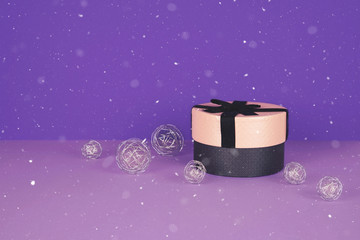 Pink gift box with ribbon on an ultraviolet background.