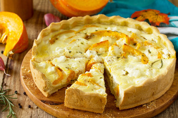 Classic Quiche Lorraine Pie with Pumpkin and Feta Cheese on a wooden table.
