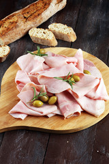 Sliced ham on wooden background. Fresh prosciutto. Pork ham sliced.