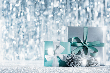 Beautiful wrapped christmas gifts and ornaments with defocused christmas lights in the background. Christmas backdrop with copy space.