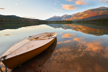 Beautiful sunset over Edith Lake with a yellow boat in foreground, Jasper National Park, Alberta, Canada