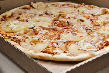 Big pizza cut into pieces in a cardboard box