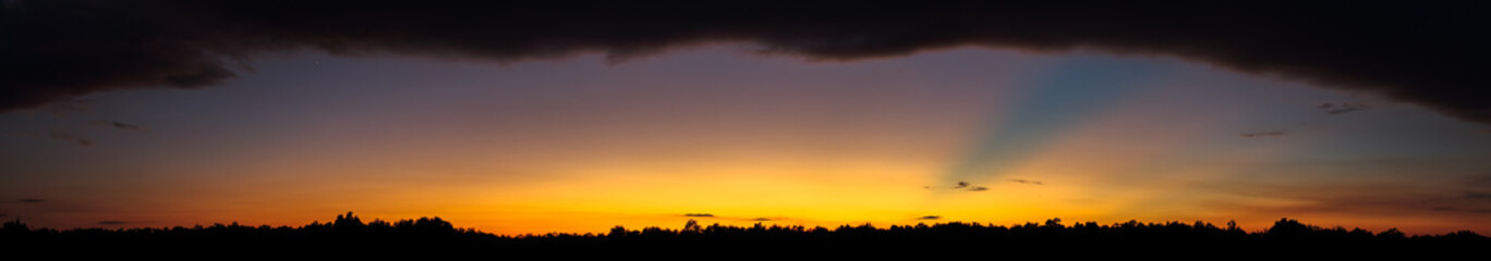 Low clouds on the horizon and the suns rays panorama